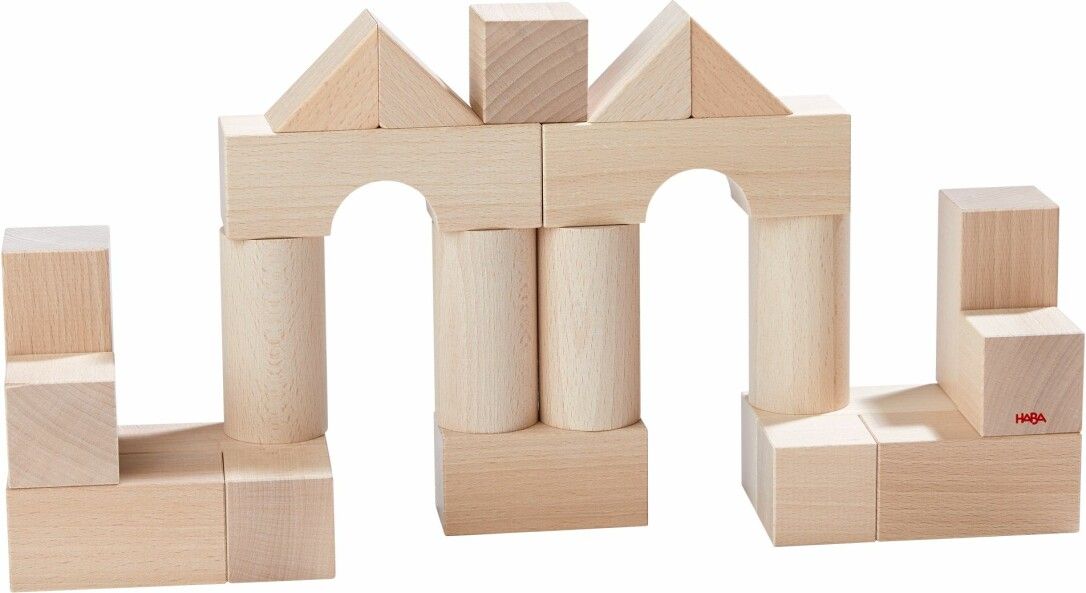 Anordnung von Holzbausteinen. Verschiedene Formen: Quadrate, Zylinder, Bögen, Dreiecke. Naturfarbenes Holz.