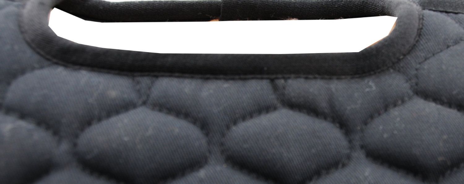 Schwarzes Sattelpad mit Steppung. Oberer Rand mit schwarzem Band eingefasst. Gepolsterte Oberfläche mit rautenförmigem Muster.