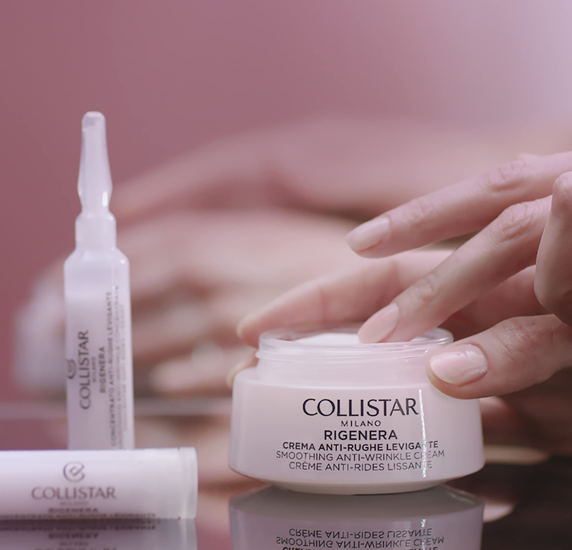 Eine Ampulle und eine Creme. Aufschrift: Collistar Milano Rigenera Crema Antirughe Levigante. Eine Hand berührt die Creme.