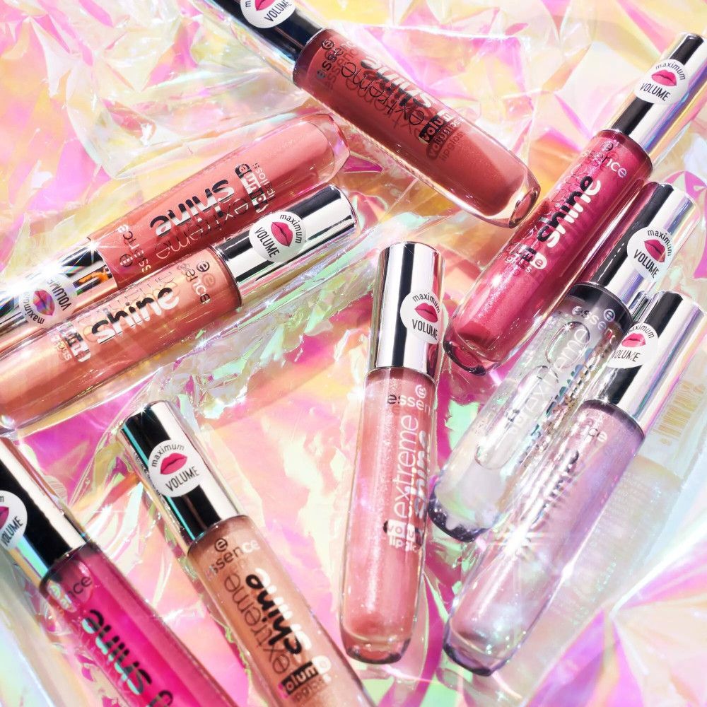 Mehrere Lipgloss-Tuben auf schillerndem Hintergrund. Verschiedene Farben und Designs. Aufschrift „extreme shine volume lipgloss“.