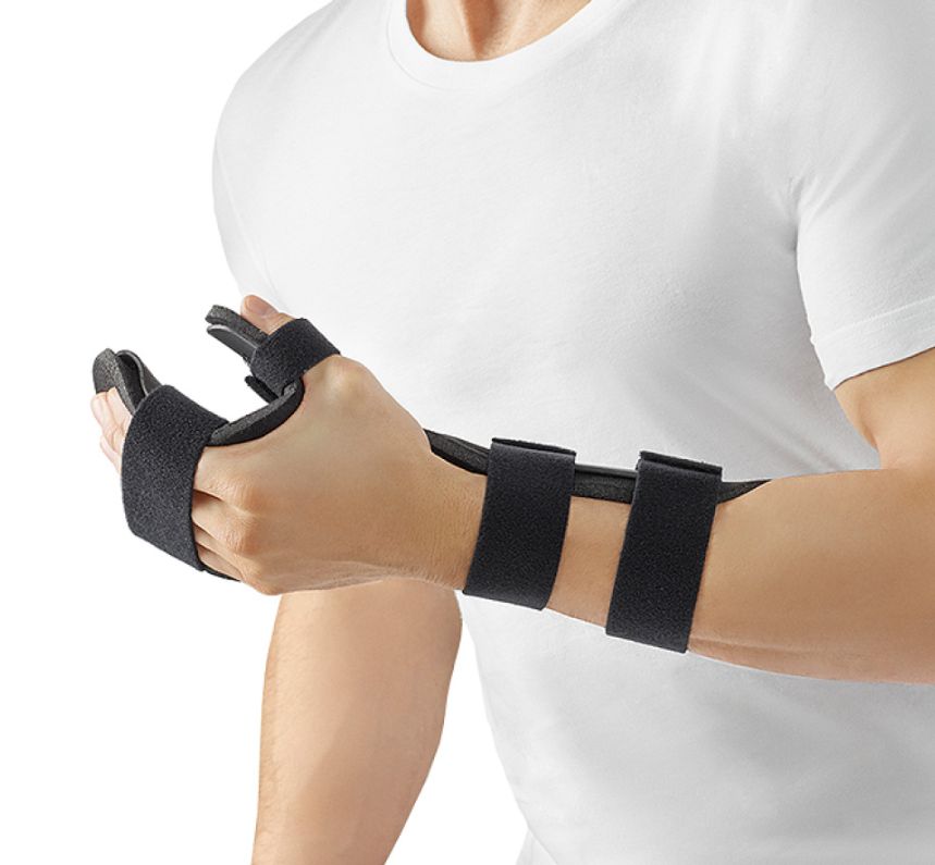 Handorthese, schwarz, mit Klettverschlüssen. Am Handgelenk und Daumen fixiert. Träger mit weißem T-Shirt.