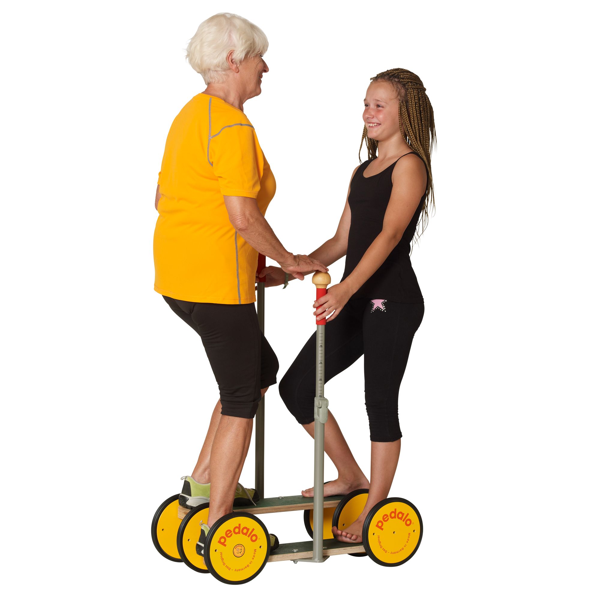 Zwei Frauen auf einem Pedalo® Combi. Eine Frau steht auf dem Gerät, die andere hält sie fest. Gelbe Räder, schwarze Trittflächen, Haltestange.