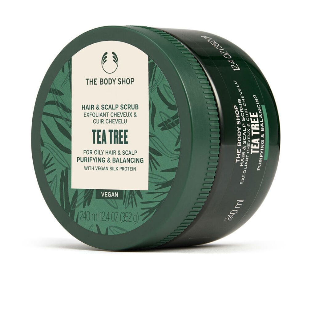 Grüne Dose mit weißem Etikett. Aufschrift: THE BODY SHOP, Hair & Scalp Scrub, Tea Tree. Vegan. 240 ml. Blattmuster.