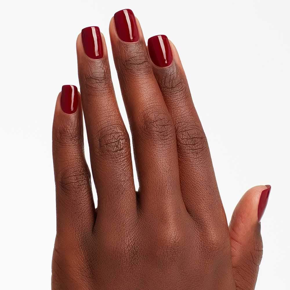 Hand mit lackierten Nägeln. Die Nägel sind mit rotem Nagellack lackiert.