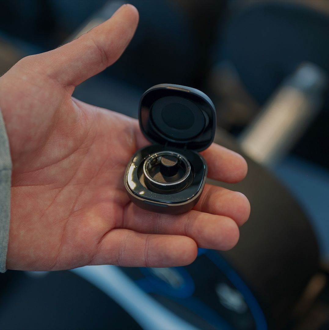 Hand hält eine schwarze Ladebox mit Ring. Ring in der Box. Schwarze Box mit Ring.