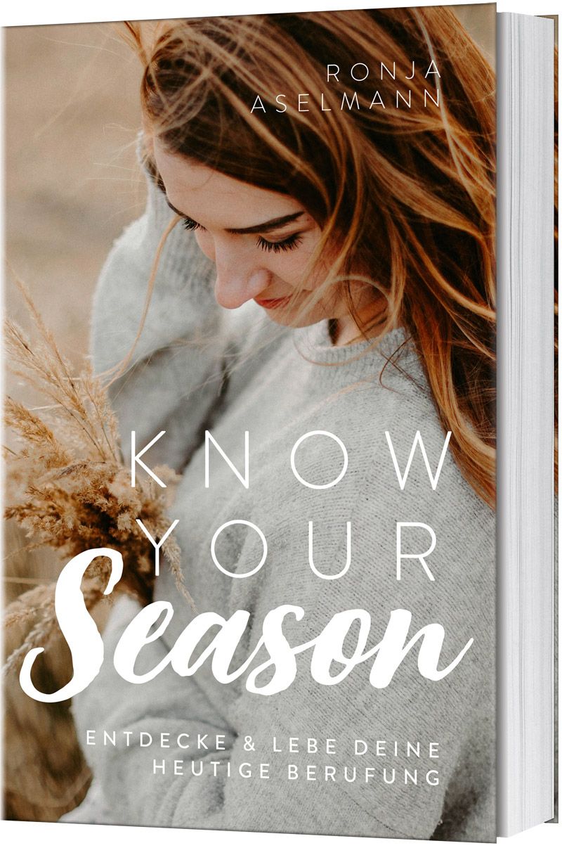 Buchcover mit Titel "Know your Season". Autorin: Ronja Aselmann. Frau mit grauem Pullover hält Zweig. Hintergrund unscharf.