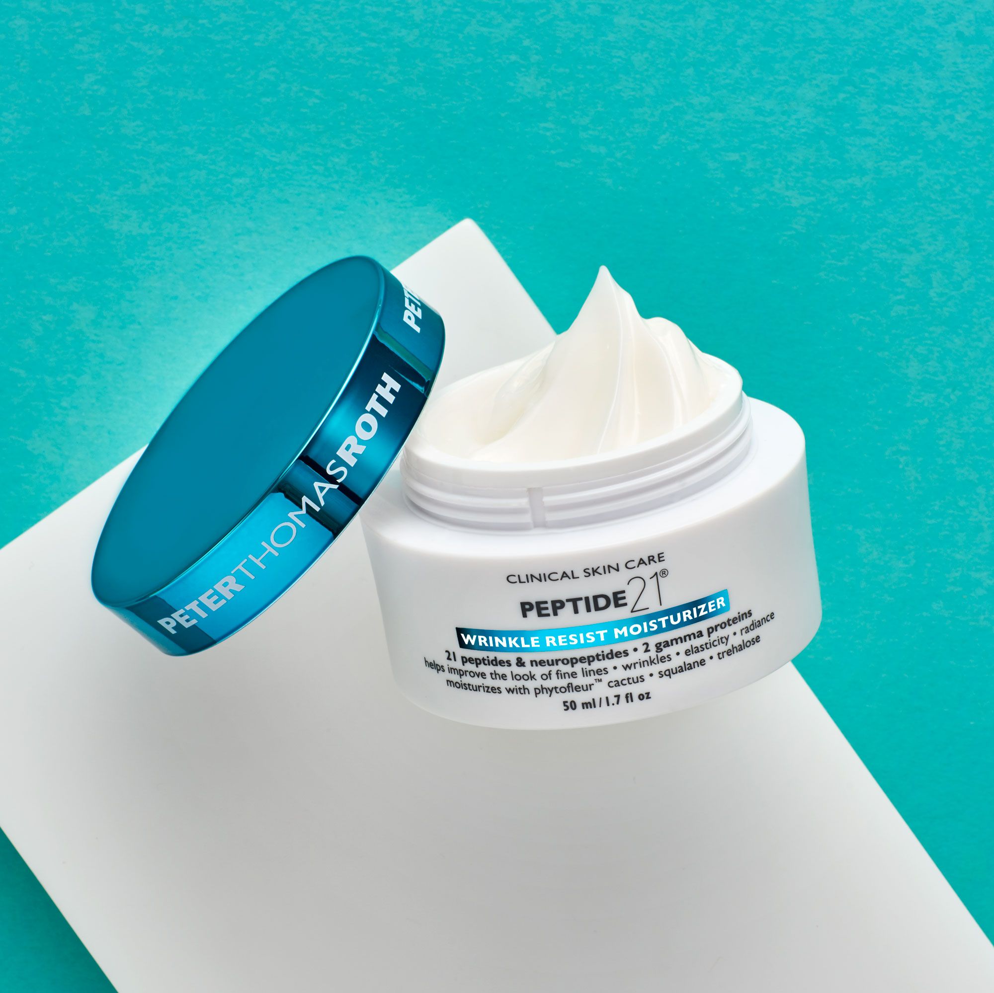 Offener weißer Tiegel mit Creme, daneben der blaue Deckel. Aufschrift: Peter Thomas Roth, Peptide 21 Wrinkle Resist Moisturizer. 50 ml/1.7 fl oz.