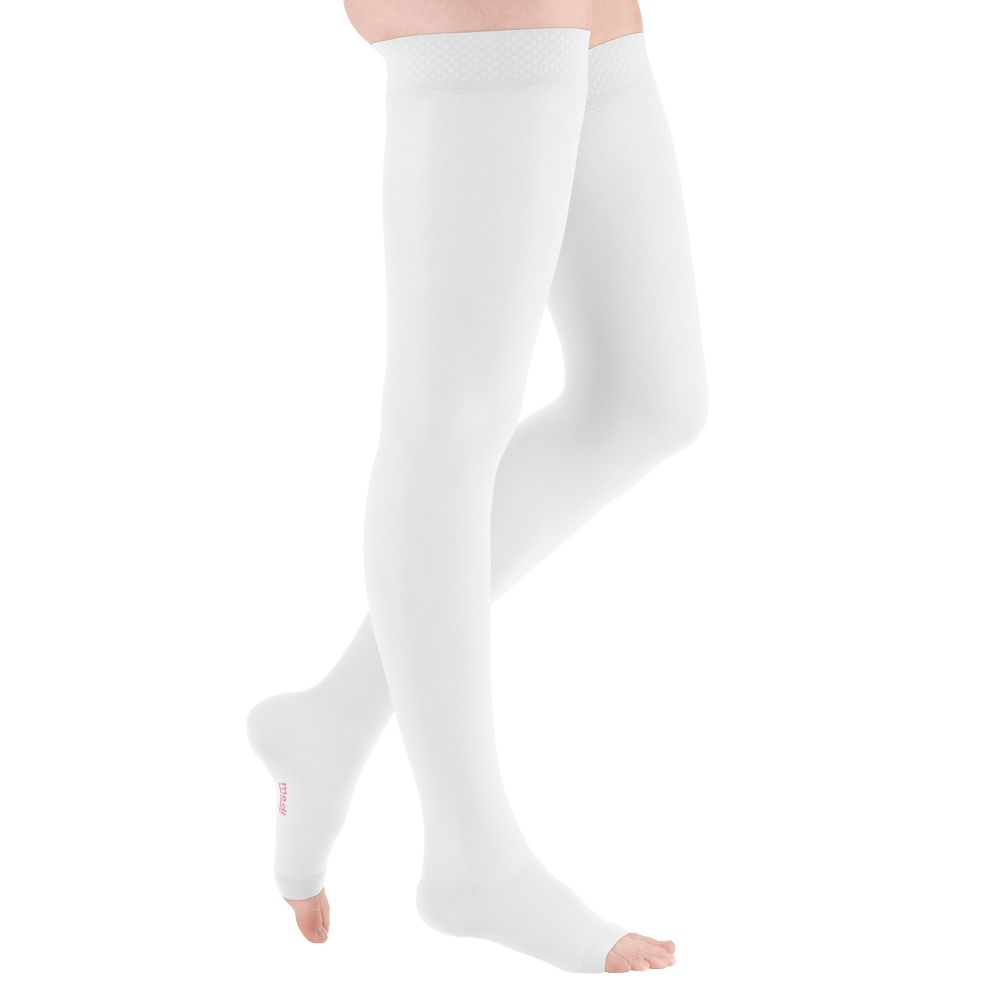 Weiße medizinische Kompressionsstrümpfe, offen an den Zehen. Sie reichen bis zum Oberschenkel und haben einen Spitzenabschlussrand.