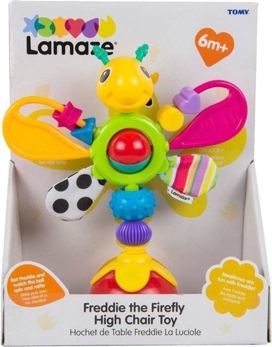 Verpackung des Spielzeugs. Es zeigt das Spielzeug, den Markennamen Lamaze und den Produktnamen Freddie the Firefly High Chair Toy.