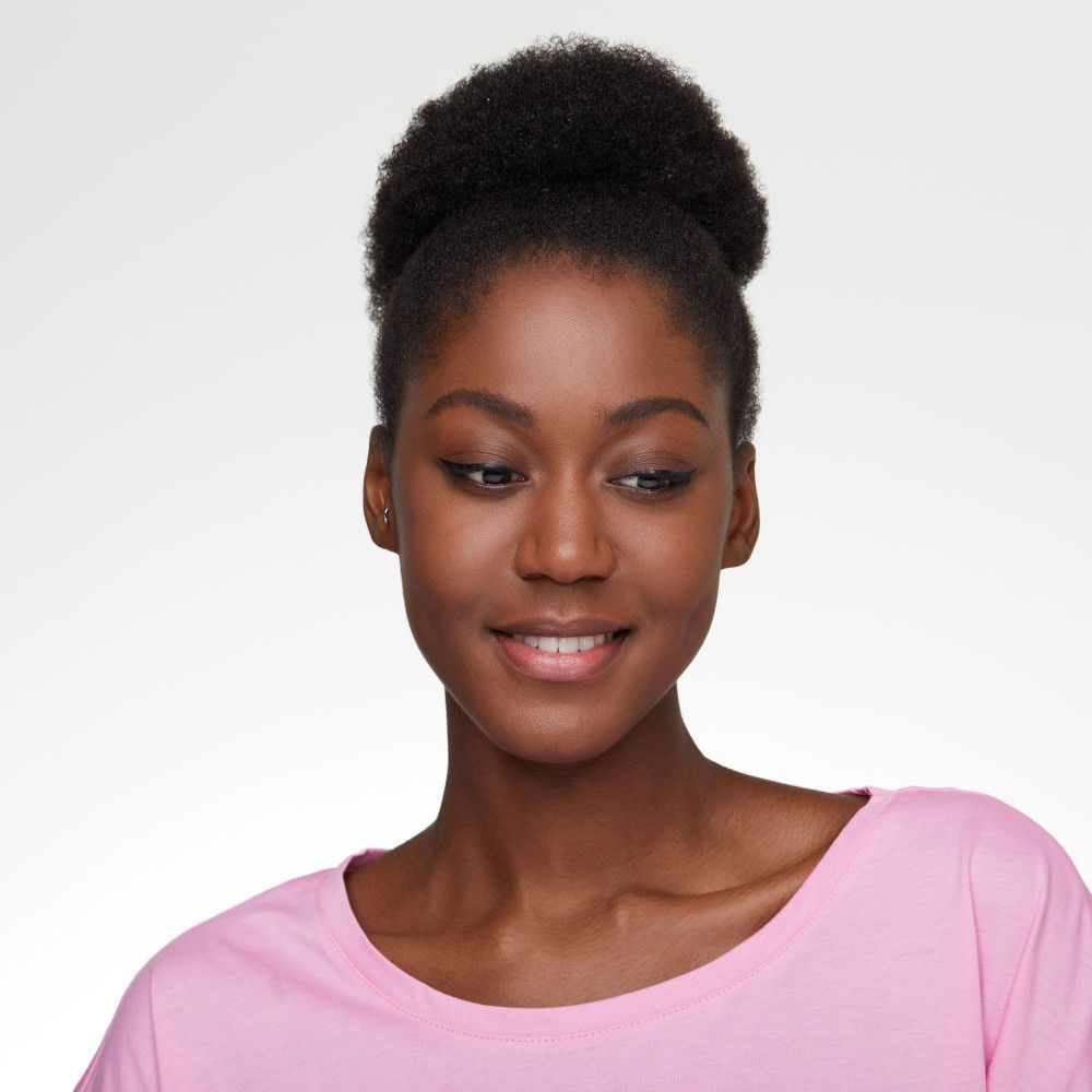 Porträt einer Frau mit Eyeliner. Sie trägt ein rosa Oberteil und blickt nach unten.