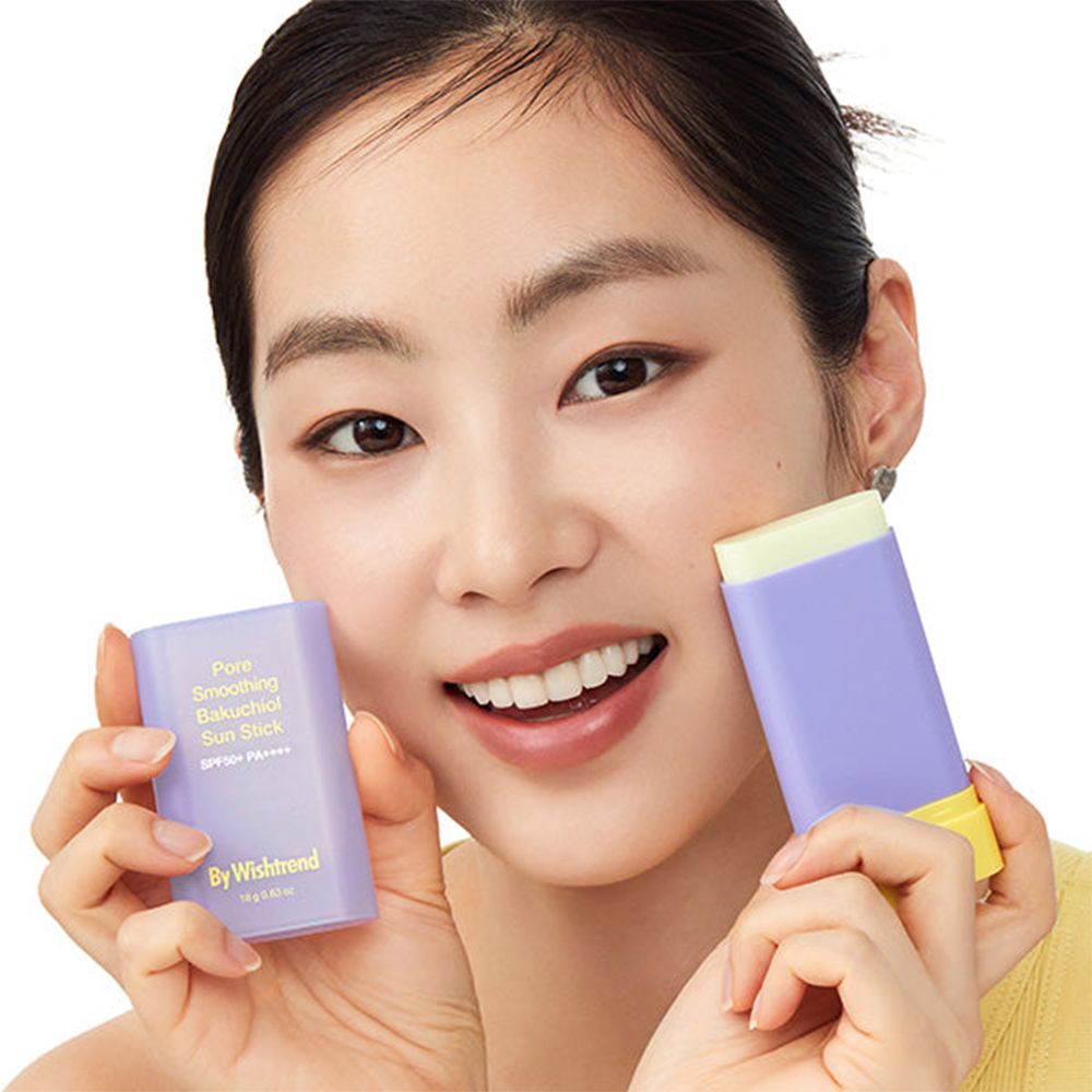 Frau hält zwei lila-gelbe Sonnenschutz-Sticks. Text: Pore Smoothing Bakuchiol Sun Stick SPF50+ PA++++. Marke: By Wishtrend.