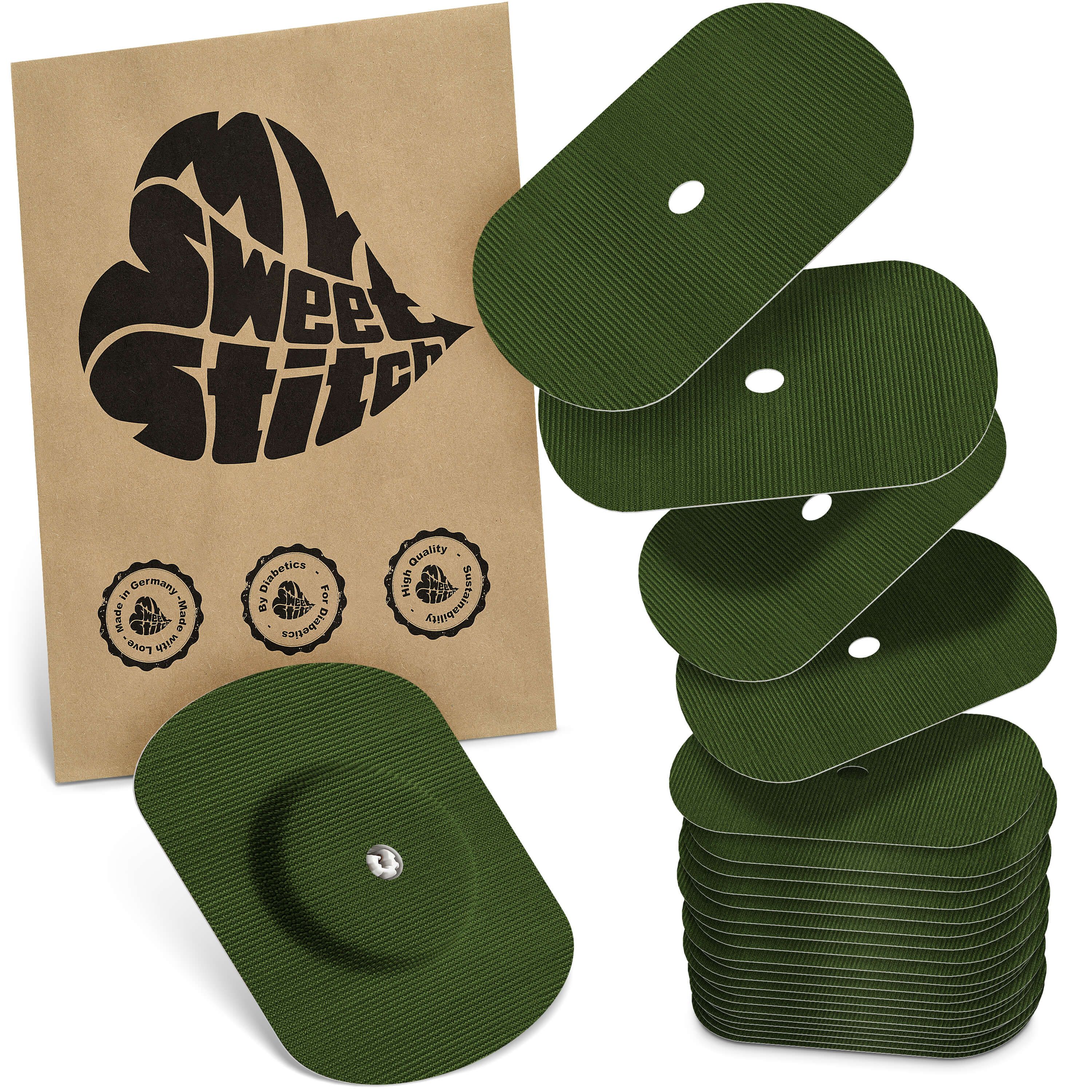 Grüne, ovale Pflaster mit Loch, neben einer braunen Verpackung mit Logo. Einige Pflaster sind gestapelt.