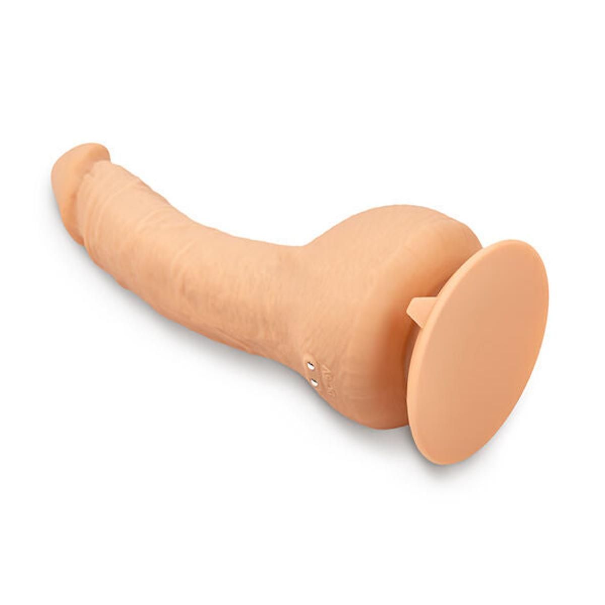 Beigefarbener Dildo mit Saugnapf. Liegend, mit Vibrationsknöpfen.