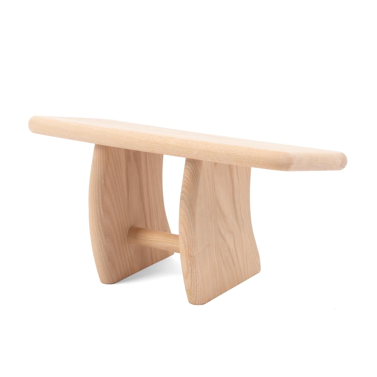 Langes, helles Holzbrett mit abgerundeten Kanten, getragen von zwei geschwungenen Beinen. Querstrebe.