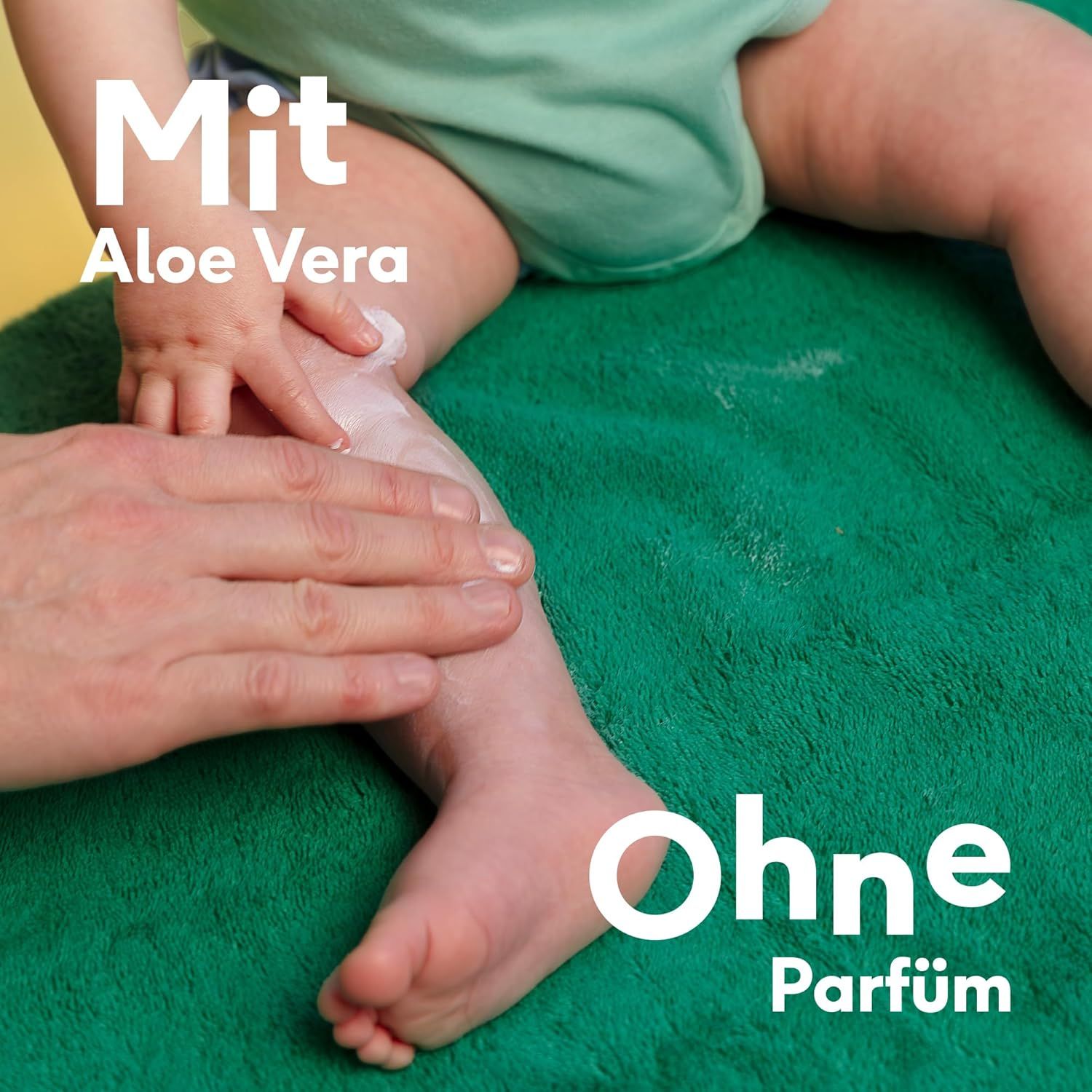 Babyfuß wird mit Creme eingerieben. Text: Mit Aloe Vera, ohne Parfum.