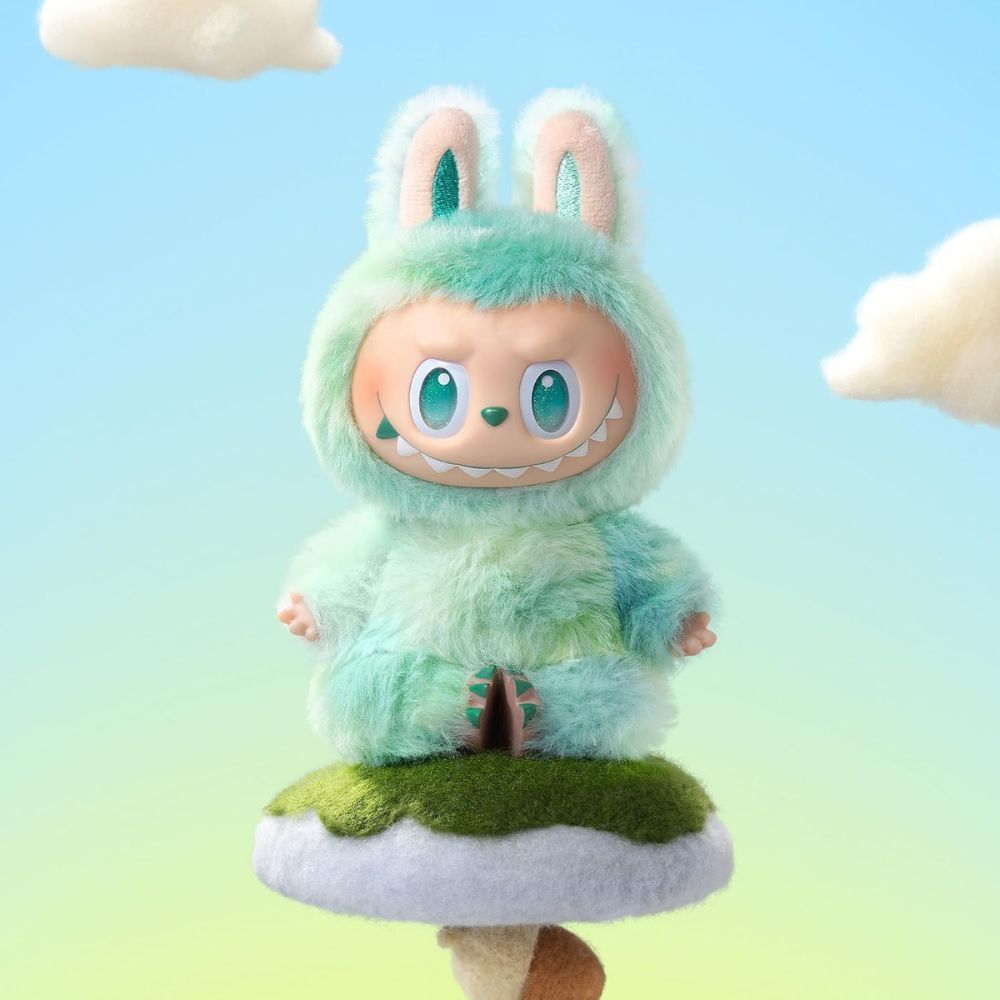 Figur auf einem Pilz. Türkis und grün. Flauschiges Material.