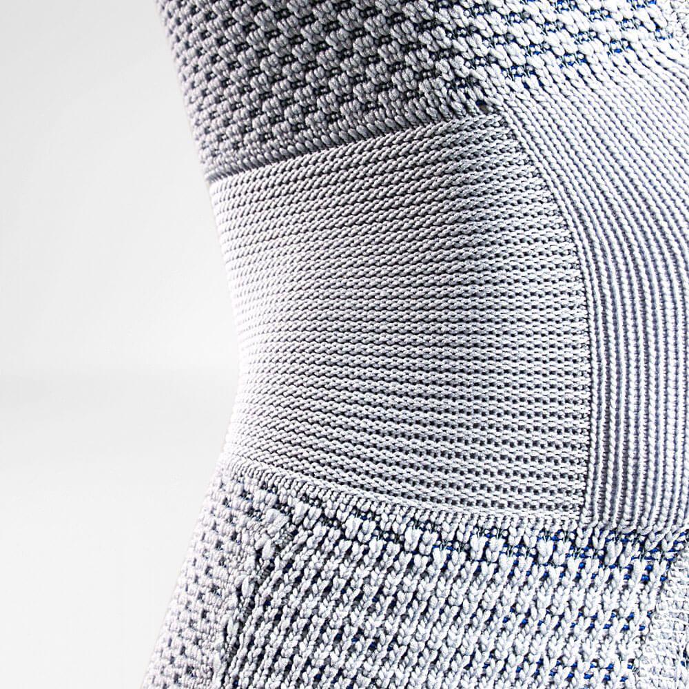 Detail der Kniebandage. Gestricktes Material, grau-blau. Verstärkte Bereiche und anatomische Form.