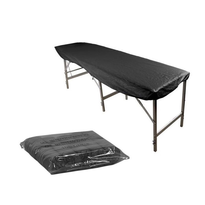 Schwarze Matratzenauflage auf einem Behandlungstisch. Darunter verpackte Auflage in Folie.