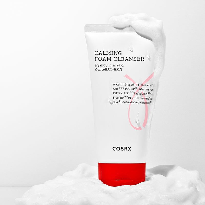 Weiße Tube mit rotem Deckel in Schaum. Aufschrift: Calming Foam Cleanser, Inhaltsstoffe. Marke: COSRX.