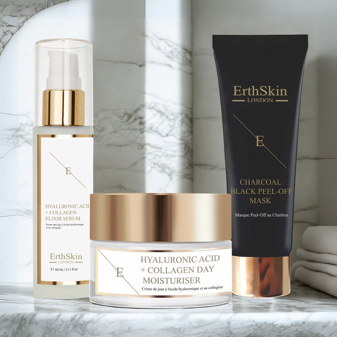 Set aus Serum, Tagescreme und Maske. Produkte mit Goldakzenten und weißem Etikett. Auf Marmoroberfläche.
