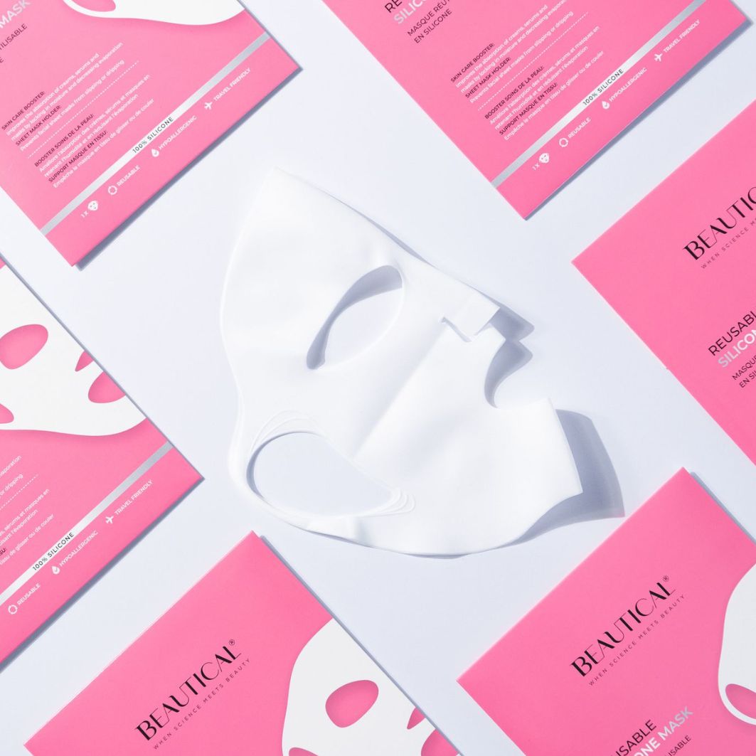 Weiße Silikonmaske und rosa Verpackungen. Text: BEAUTICAL, REUSABLE SILICONE MASK. Maske liegt auf Verpackungen.