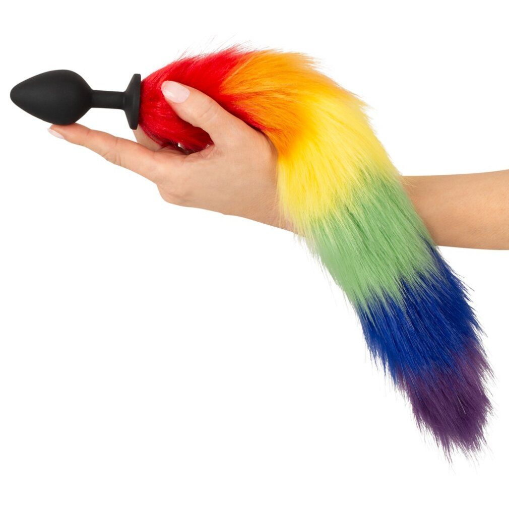 Hand hält einen Regenbogenfarbenen Fluffy Tail mit schwarzem Stecker.