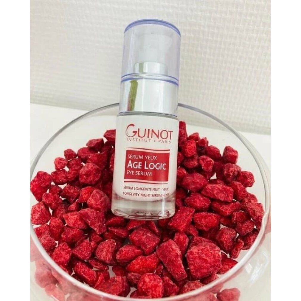Serumflasche in Schale mit roten Beeren. Aufschrift: Guinot, Age Logic Eye Serum. Transparente Flasche mit silberner Pumpe.