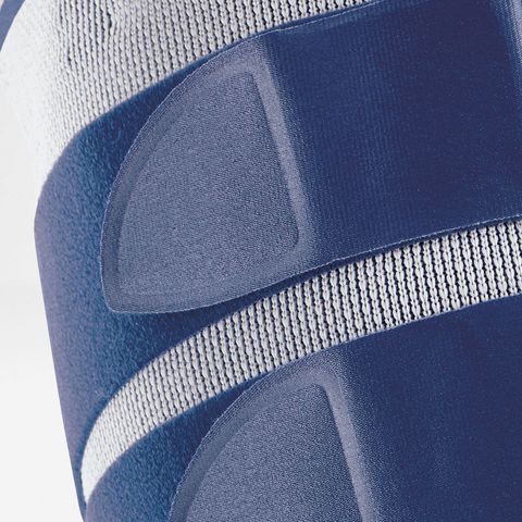 Nahaufnahme der MyoTrain Oberschenkelbandage. Blaue Klettverschlüsse und weißes, gestreiftes Material.