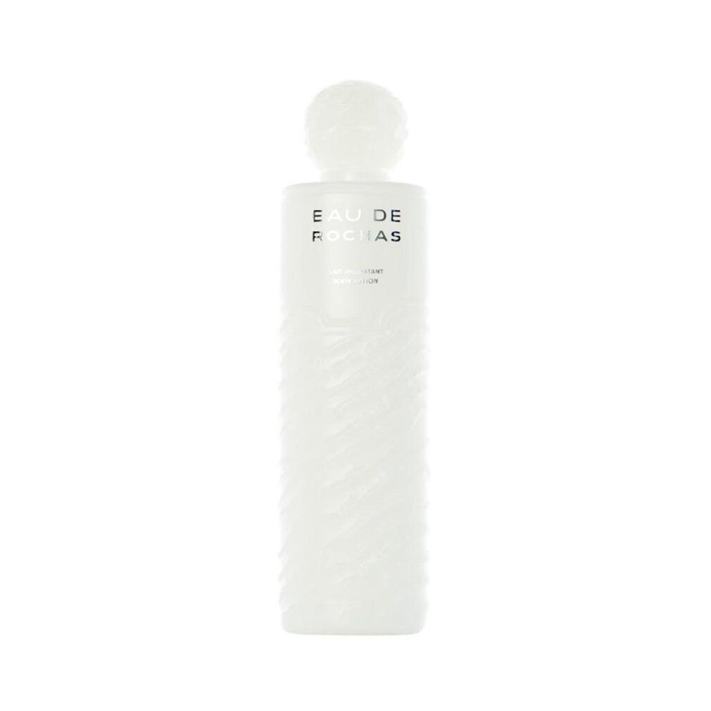Weiße Flasche mit geriffelter Oberfläche. Oben steht "EAU DE ROCHAS". Darunter "LAIT PARFUMÉ POUR LE CORPS".