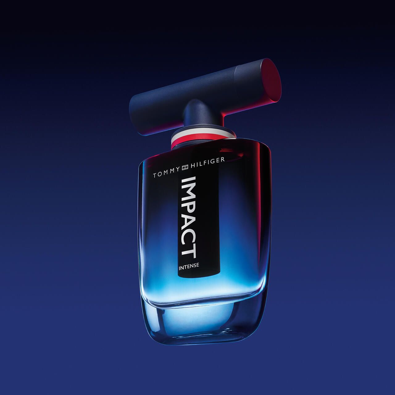 Tommy Hilfiger Impact Intense EdP Nat. Spray. Blaue Glasflasche, schwarzer Verschluss. Aufschrift IMPACT.