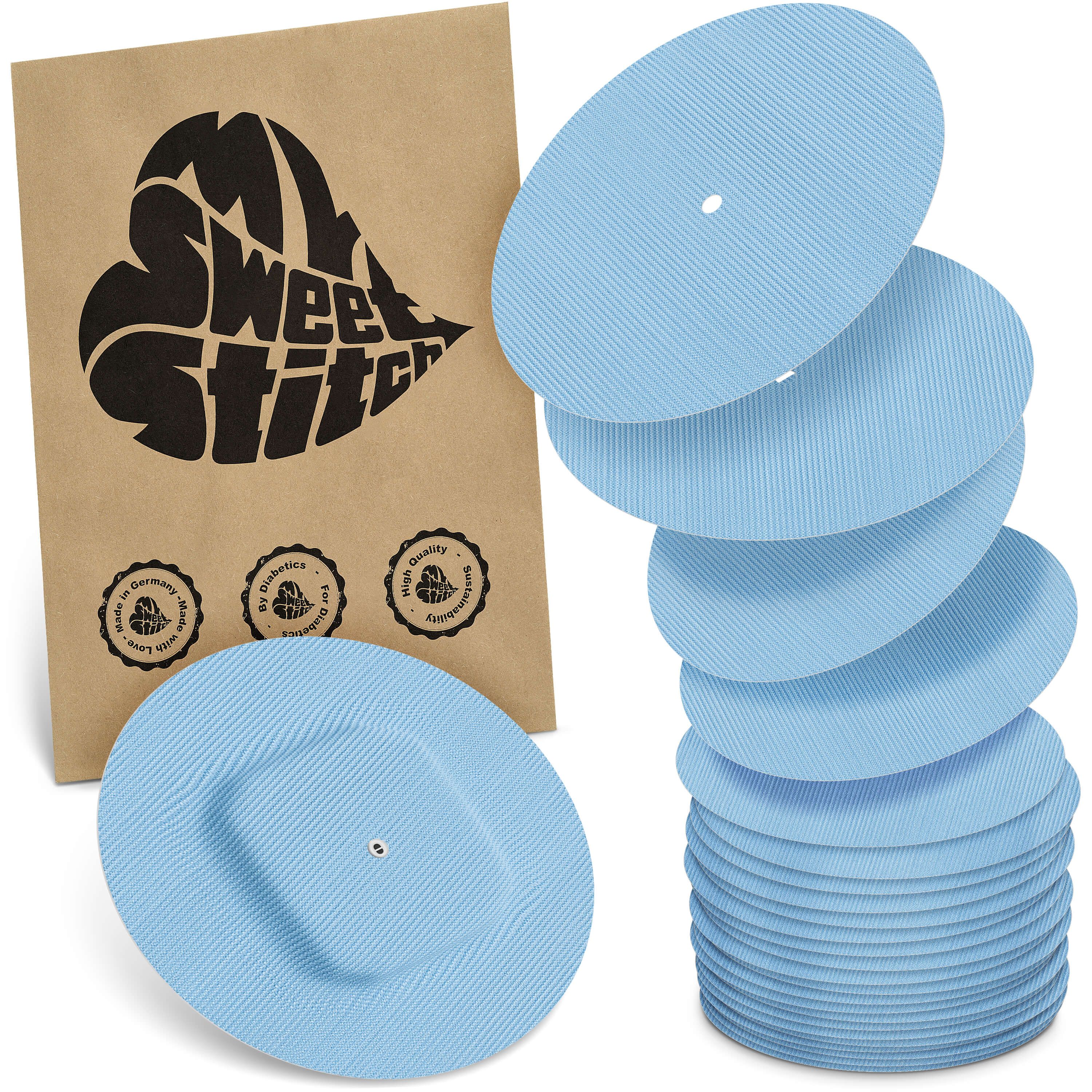 Hellblaue, runde Pflaster mit einem zentralen Loch. Eine Packung mit Logo und Qualitätssiegeln ist sichtbar.