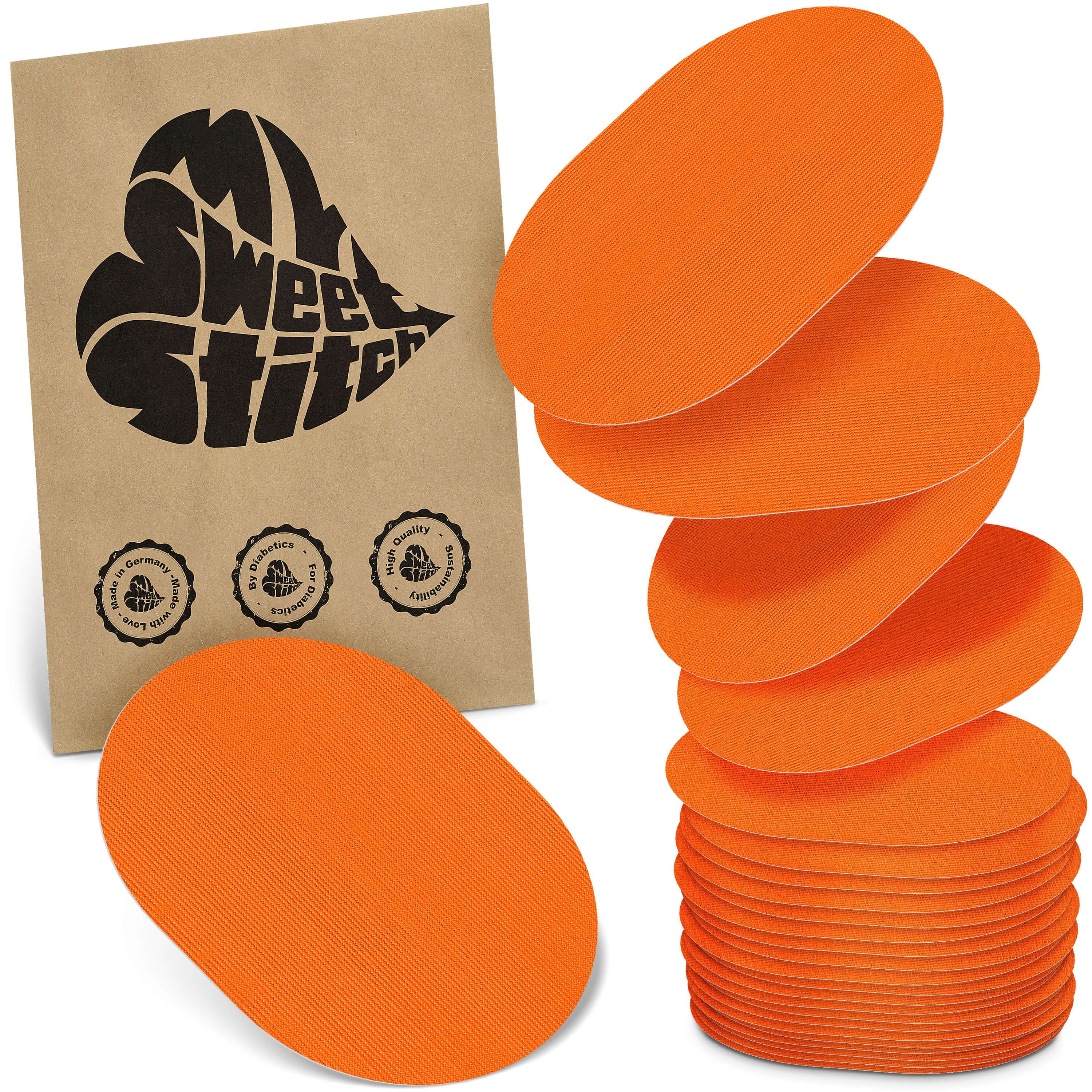 Orange ovale Pflaster mit Rillenstruktur, gestapelt und einzeln. Braune Packung mit Herz-Logo und Qualitätssiegeln.